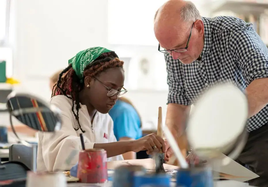 Art teacher helping student in lesson